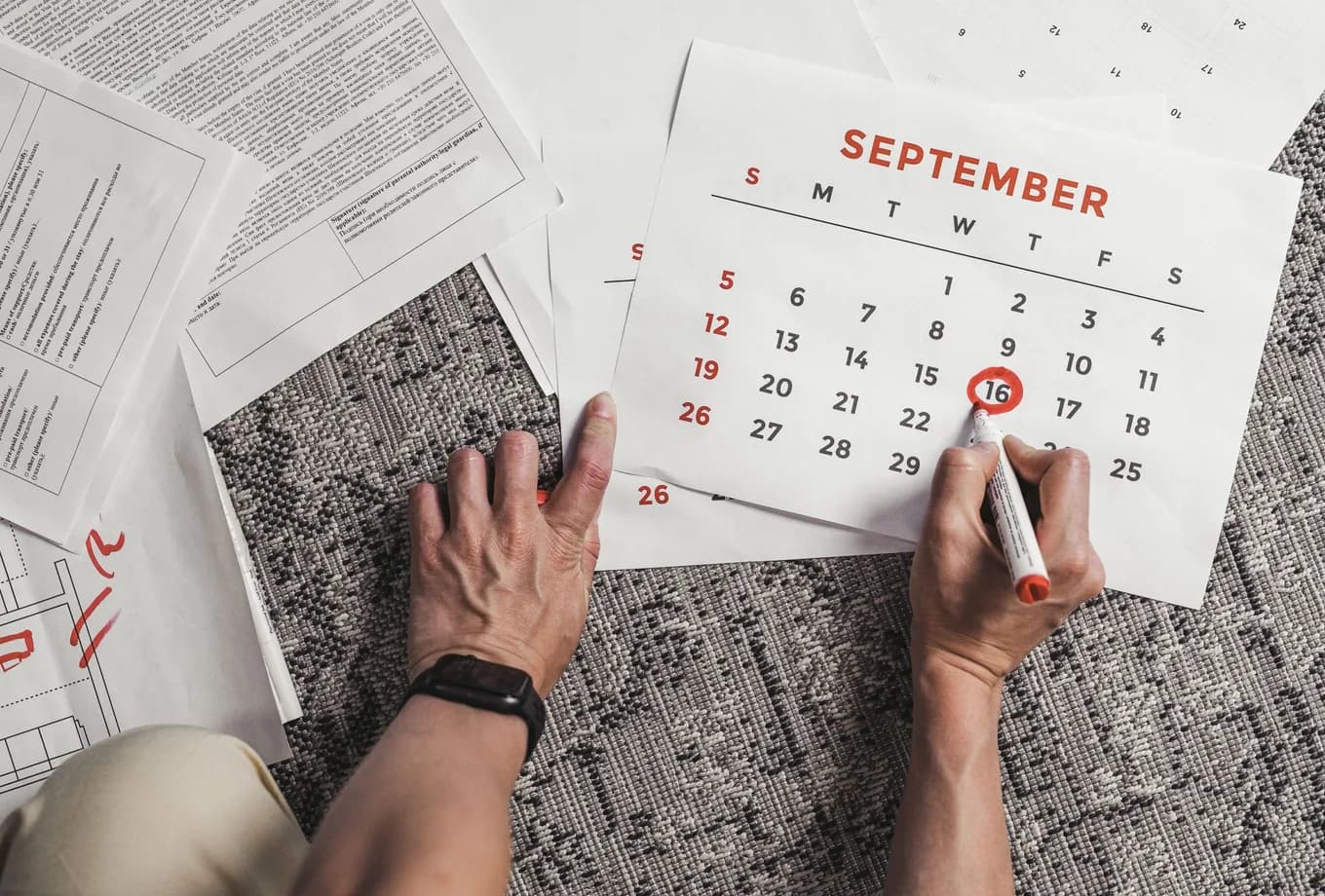 A hand circling a date on a September calendar.